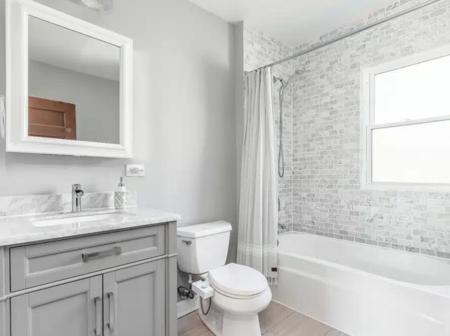 grey bathroom with tub liner, and tiled wall