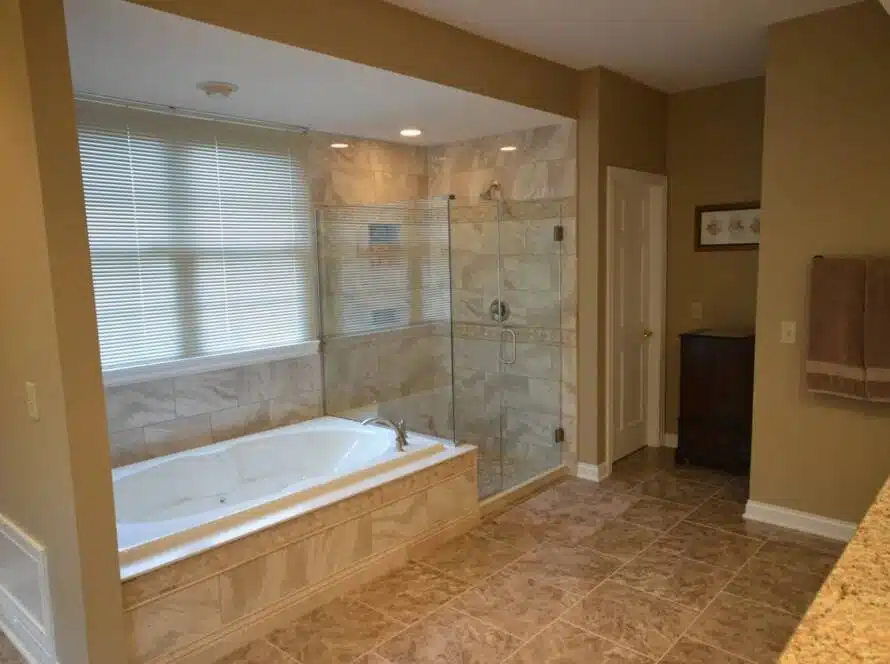 Fully tiled bathroom remodel project with a bathtub and shower combination.