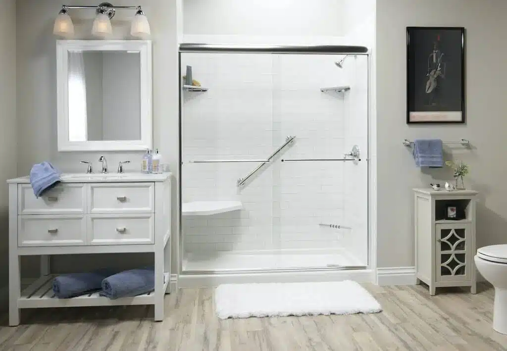 Clean and artistic bathroom design with a large vanity, towel storage below the countertop, and large tiled shower.