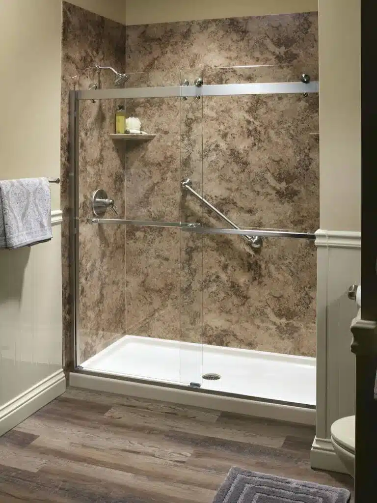 Warm brown tiled shower in bathroom with wooden floors.