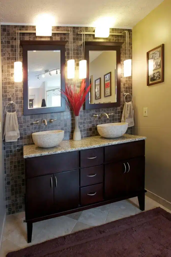 Exotic bathroom design with patterned bathroom tile, red accents, and dark colored bathroom cabinets.