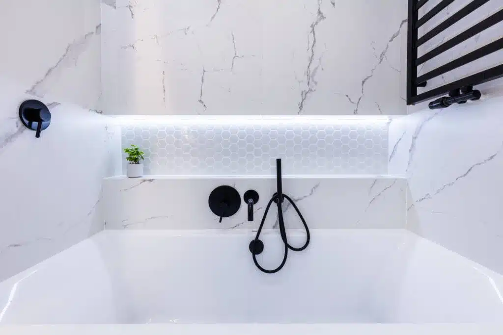 A modern bathroom design with a smart handheld faucet and white honeycomb tile.