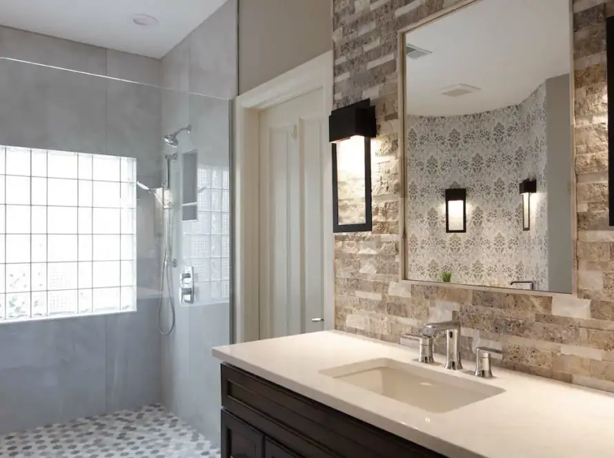 Bathroom remodel with textured faux-brick tile and filigree wallpapper.