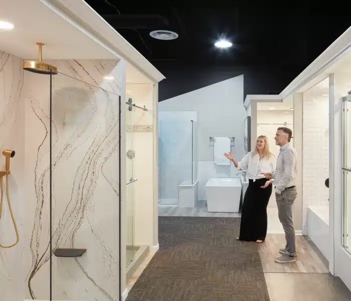 Two people smiling looking at bathroom design displays at Columbus Bath Design's Design Center in Lewis Center, Ohio.